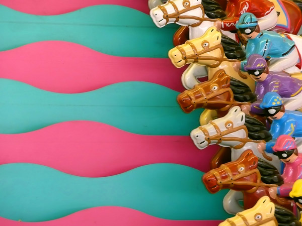 Brightly colored, metal jockeys and horses wait to
race.