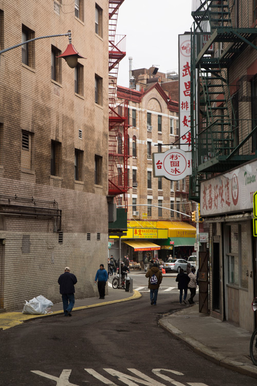 People walking down a curved street.