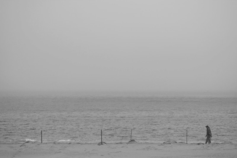 A lone figure walking on a beach