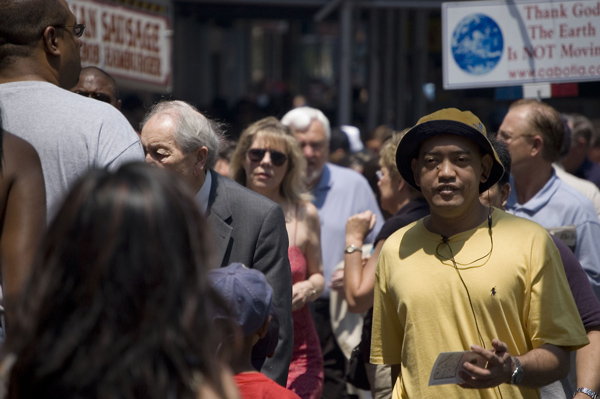 A pedestrian in Times Square walks calmly amid the clamor