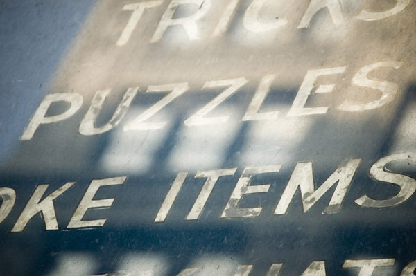 Gold leaf letters list the offerings of a long-gone shop.